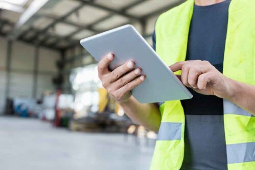 Restoration technician using a digital tablet inside a commercial warehouse